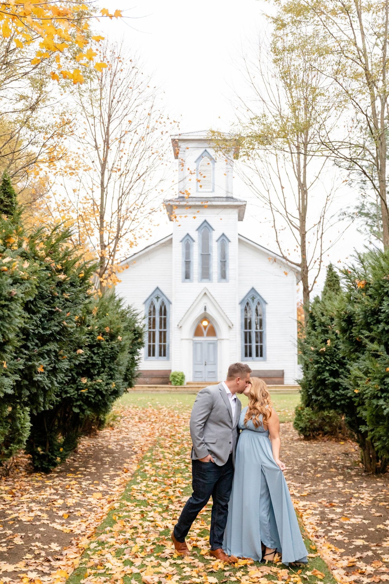 Romantic Cranberry Creek engagement session of a couple kissing in front of the chapel